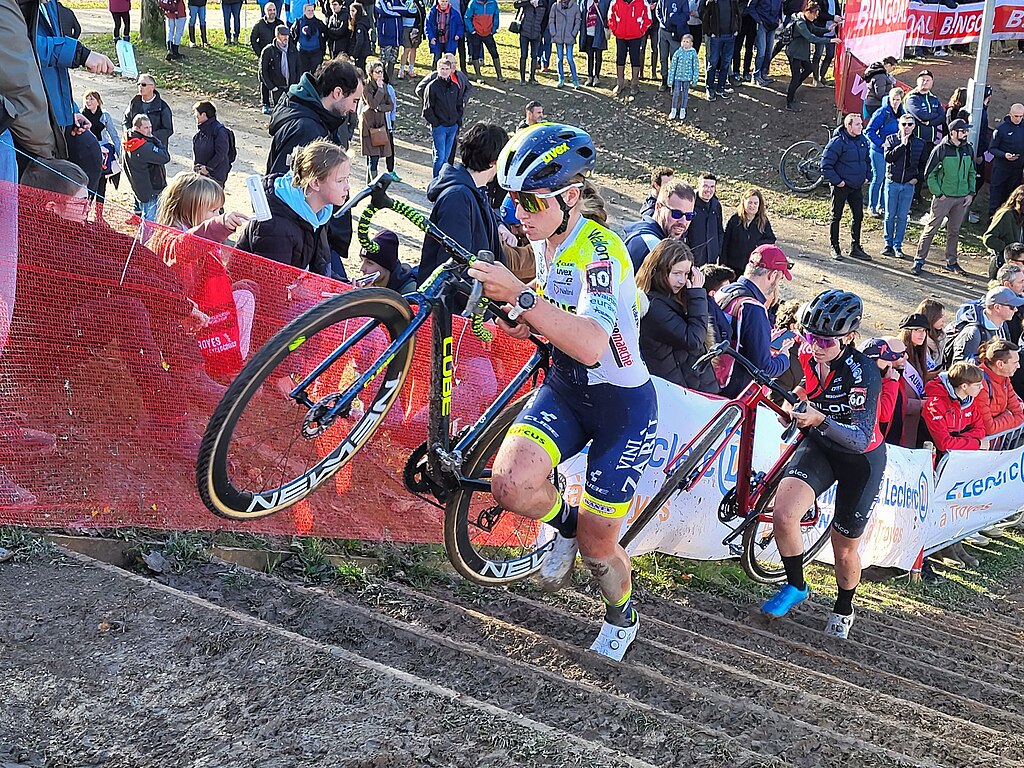 prova de cyclocross com ciclistas carregando bicicletas nas escadas